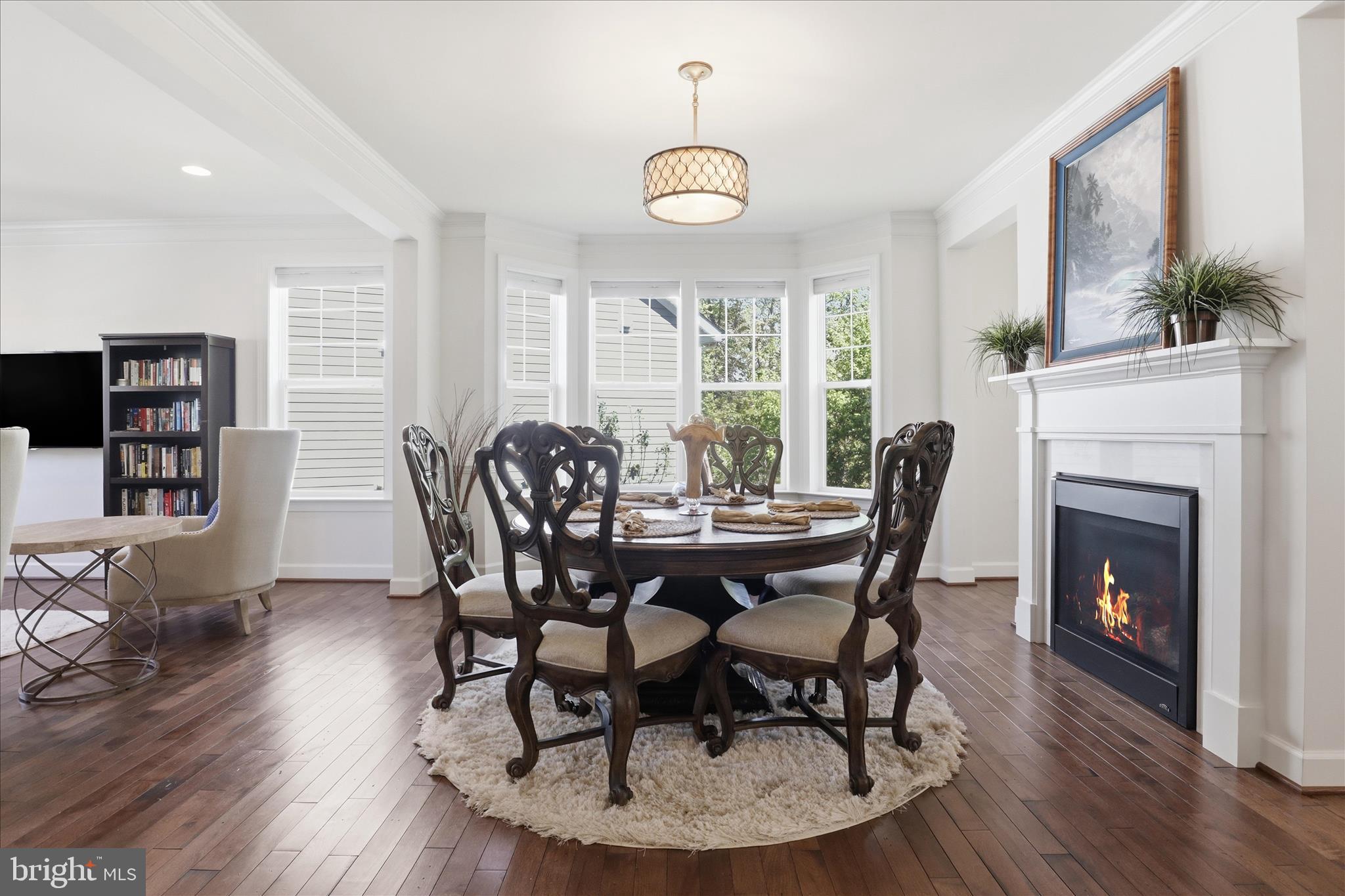 8383 Edward Carr Court Springfield, VA 22153 - Photo 6 of 57 a dining room with furniture a fireplace and wooden floor