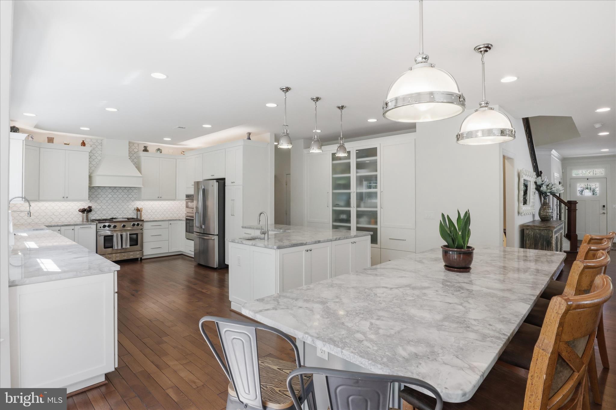 8383 Edward Carr Court Springfield, VA 22153 - Photo 10 of 57 a kitchen with stainless steel appliances kitchen island granite countertop a table chairs and a refrigerator