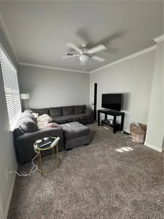 a living room with furniture a ceiling fan and a window