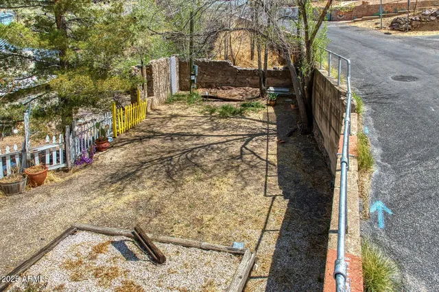 a view of a yard with wooden fence