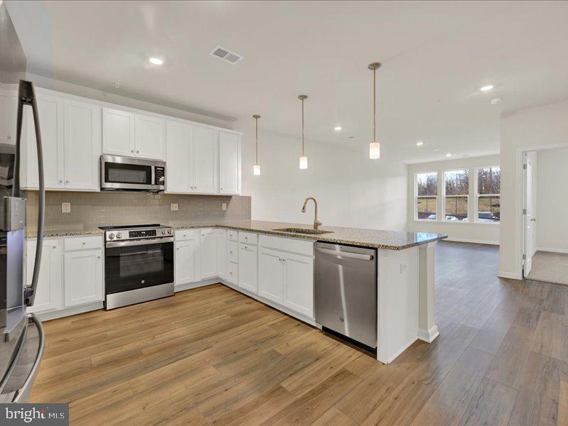 a kitchen with stainless steel appliances granite countertop a stove a sink and a refrigerator