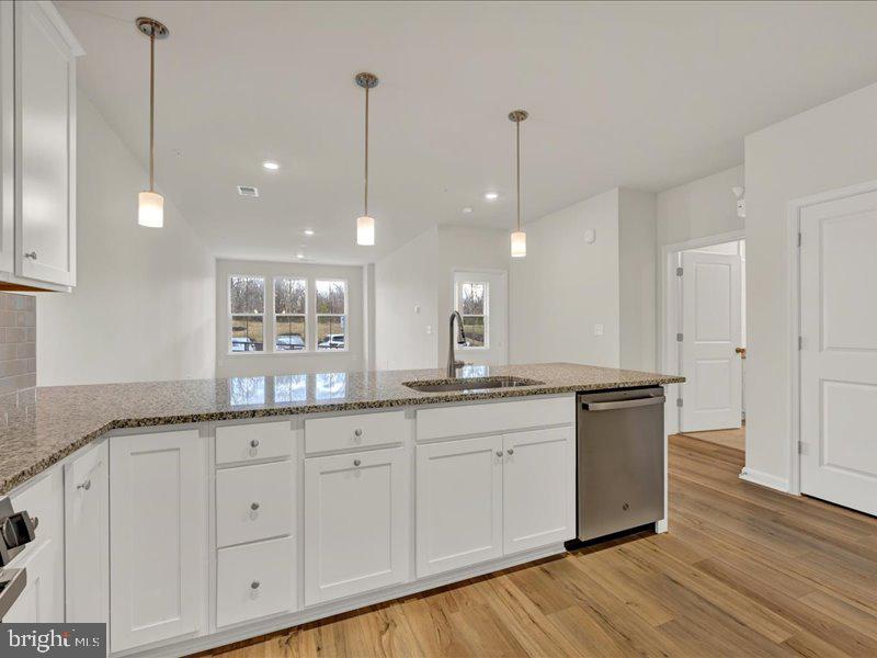 4005 Seaside Alder Road, Unit D Bowie, MD 20720 - Photo 11 of 41 a large kitchen with granite countertop a oven a sink white cabinets and a wooden floors