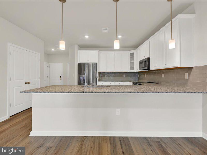4005 Seaside Alder Road, Unit D Bowie, MD 20720 - Photo 17 of 41 a view of kitchen with stainless steel appliances granite countertop cabinets and wooden floor