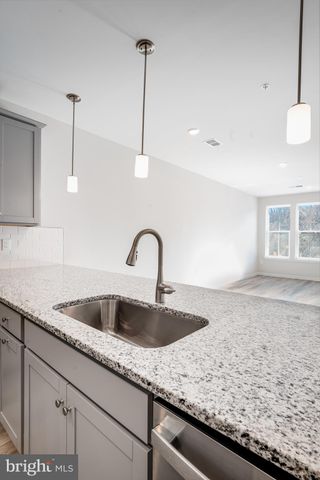 a kitchen with granite countertop a sink and a wooden floor