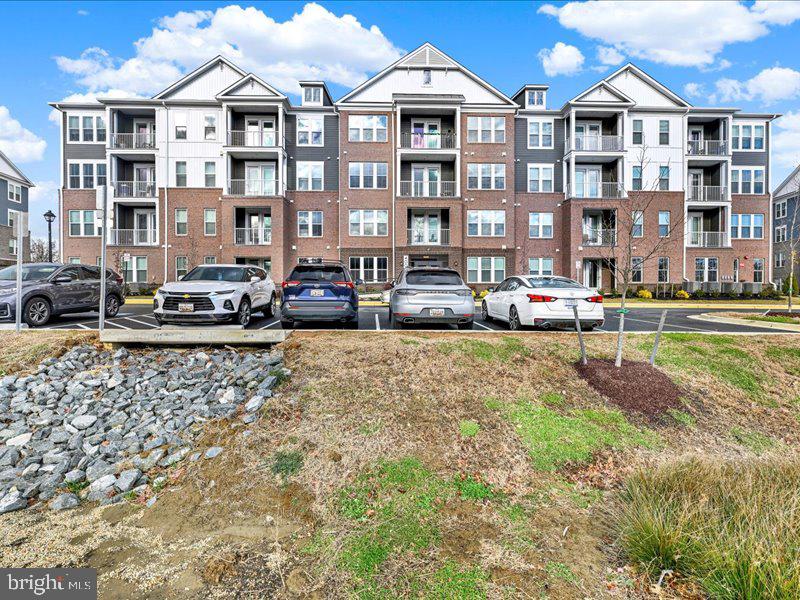 4005 Seaside Alder Road, Unit D Bowie, MD 20720 - Photo 35 of 41 a front view of a building with lot of cars and trees
