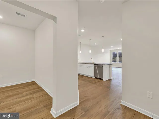 a kitchen with stainless steel appliances granite countertop a sink a stove a refrigerator and cabinets with wooden floor