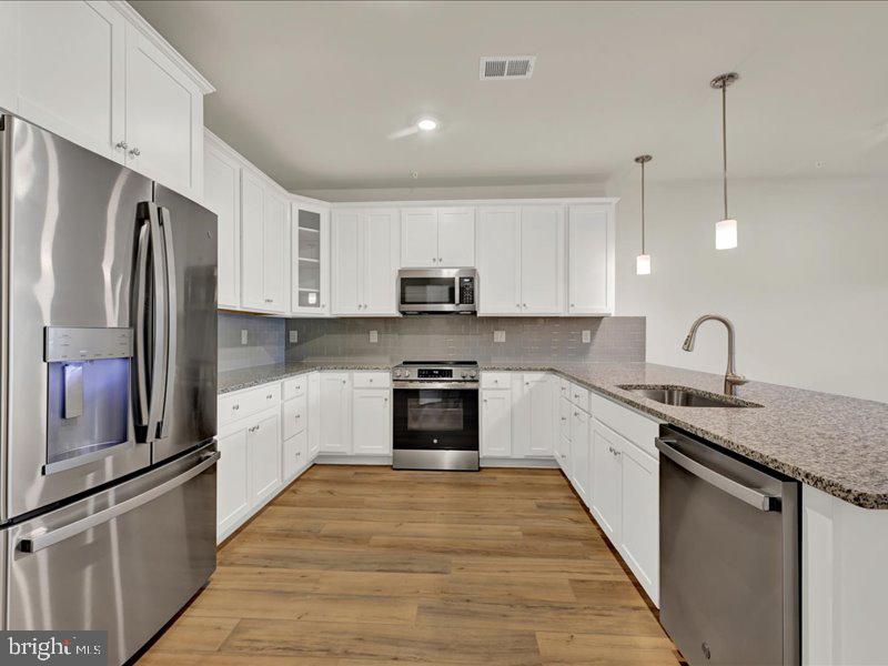 4005 Seaside Alder Road, Unit D Bowie, MD 20720 - Photo 7 of 41 a kitchen with granite countertop a refrigerator stove top oven and sink