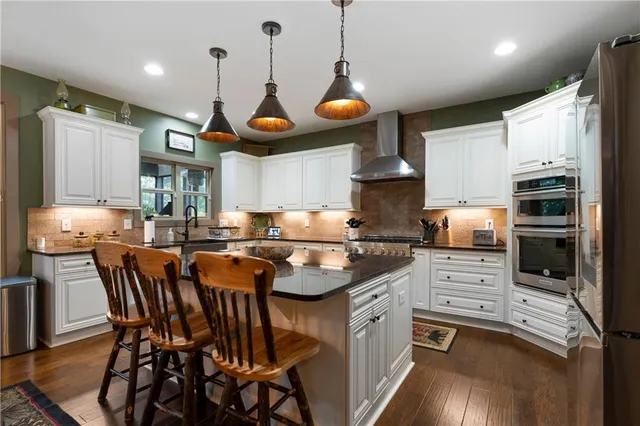 a kitchen with stainless steel appliances granite countertop a stove a sink and a refrigerator