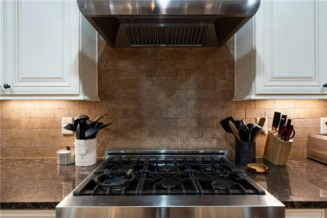 a kitchen with stainless steel appliances granite countertop a sink a counter space and cabinets