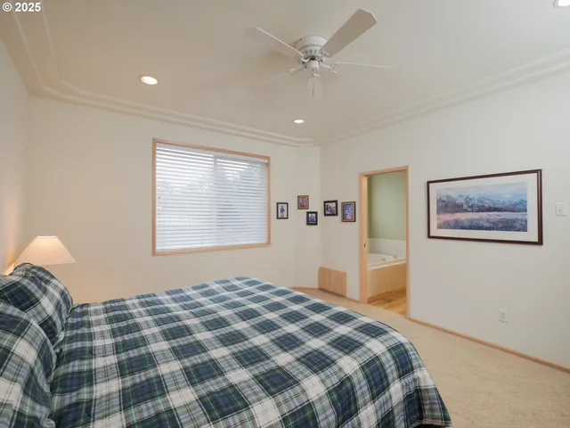 a bedroom with a bed and a painting on the wall