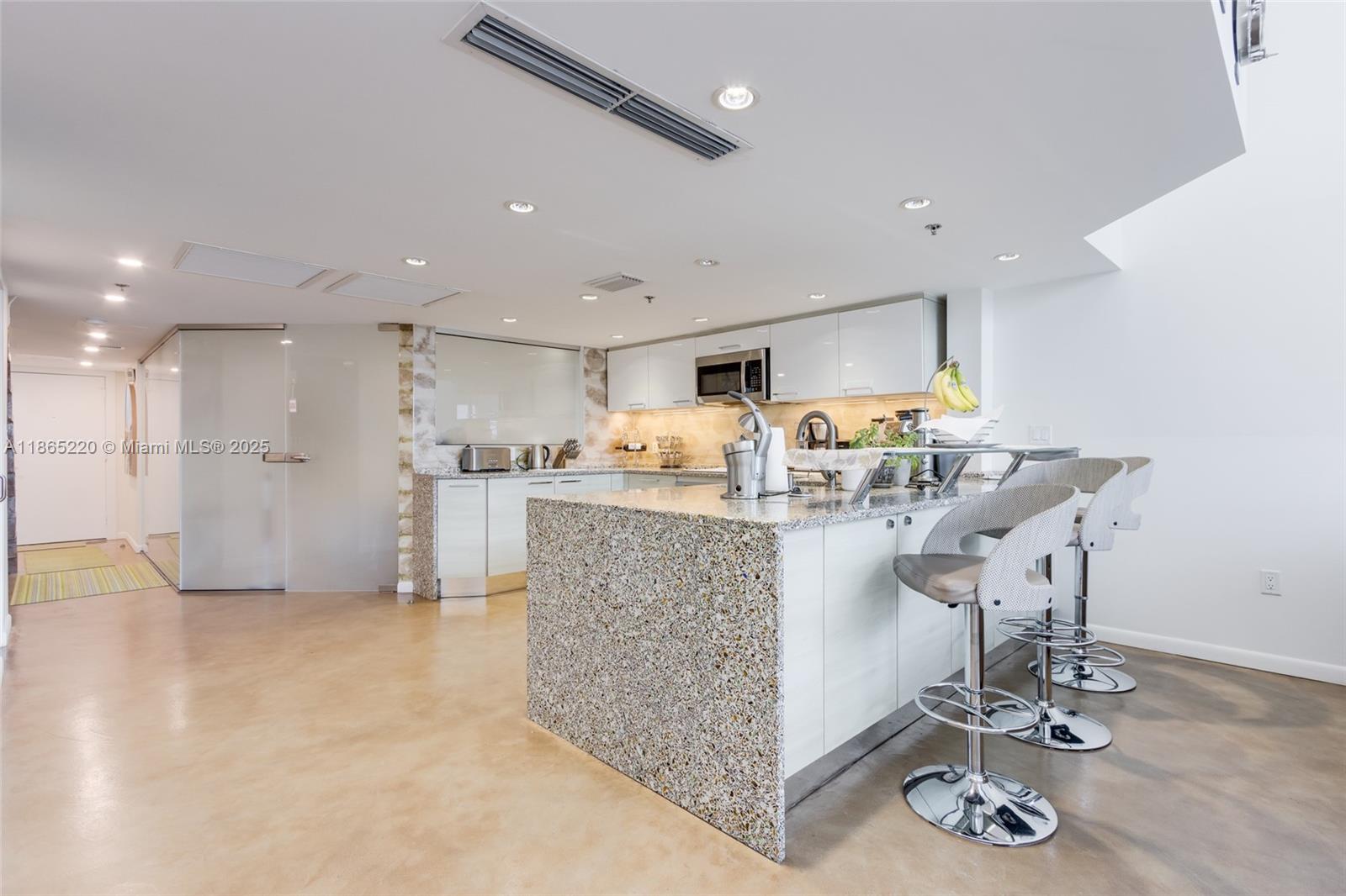 5445 Collins Avenue, Unit P2 Miami Beach, FL 33140 - Photo 12 of 62 a kitchen with stainless steel appliances granite countertop a sink and a refrigerator