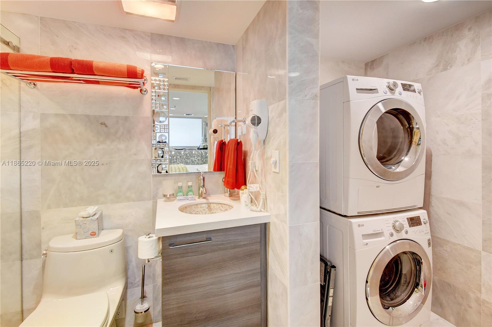 5445 Collins Avenue, Unit P2 Miami Beach, FL 33140 - Photo 28 of 62 a bathroom with a sink a washer and dryer