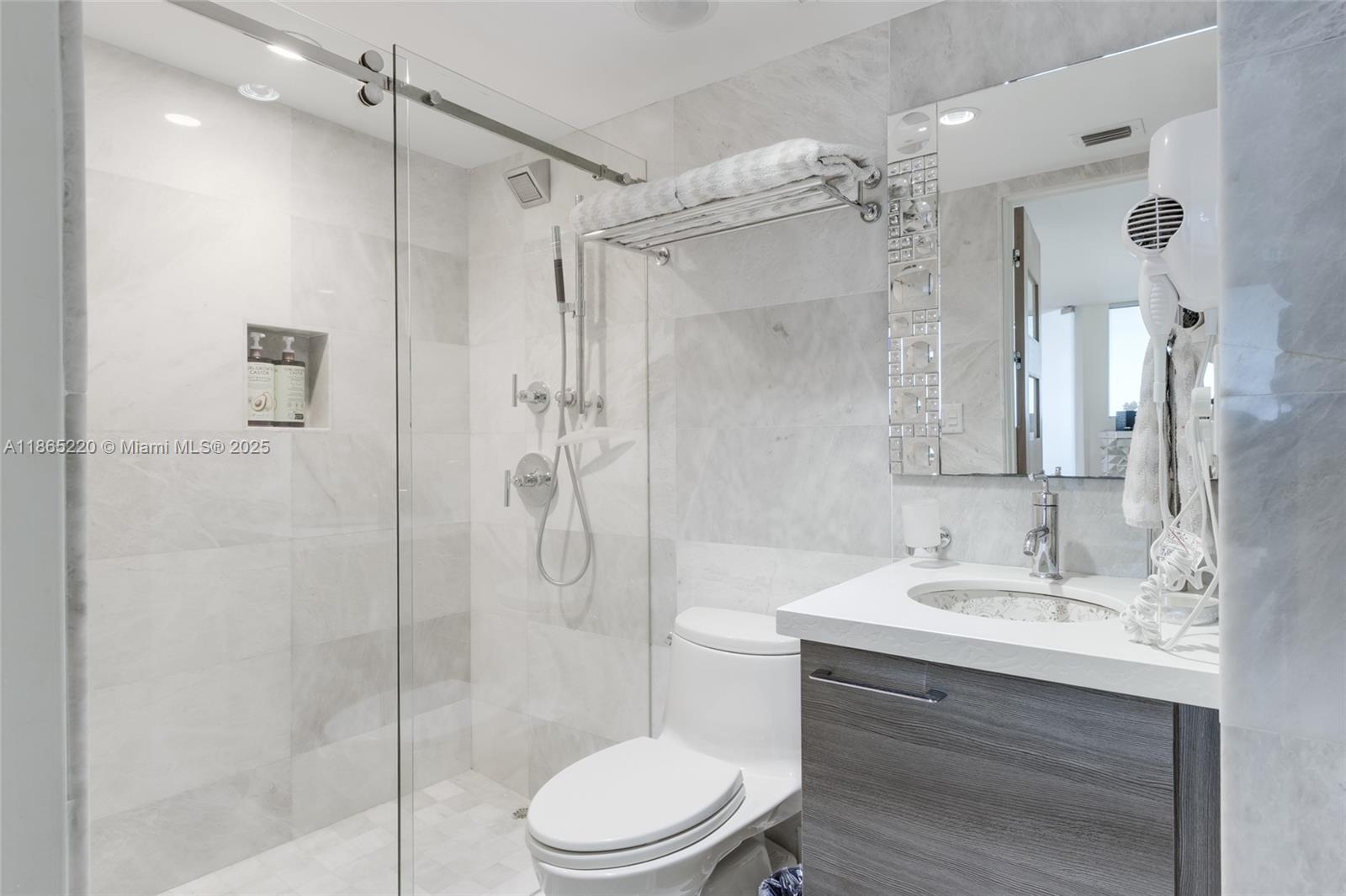 5445 Collins Avenue, Unit P2 Miami Beach, FL 33140 - Photo 52 of 62 a bathroom with a sink vanity granite toilet and shower