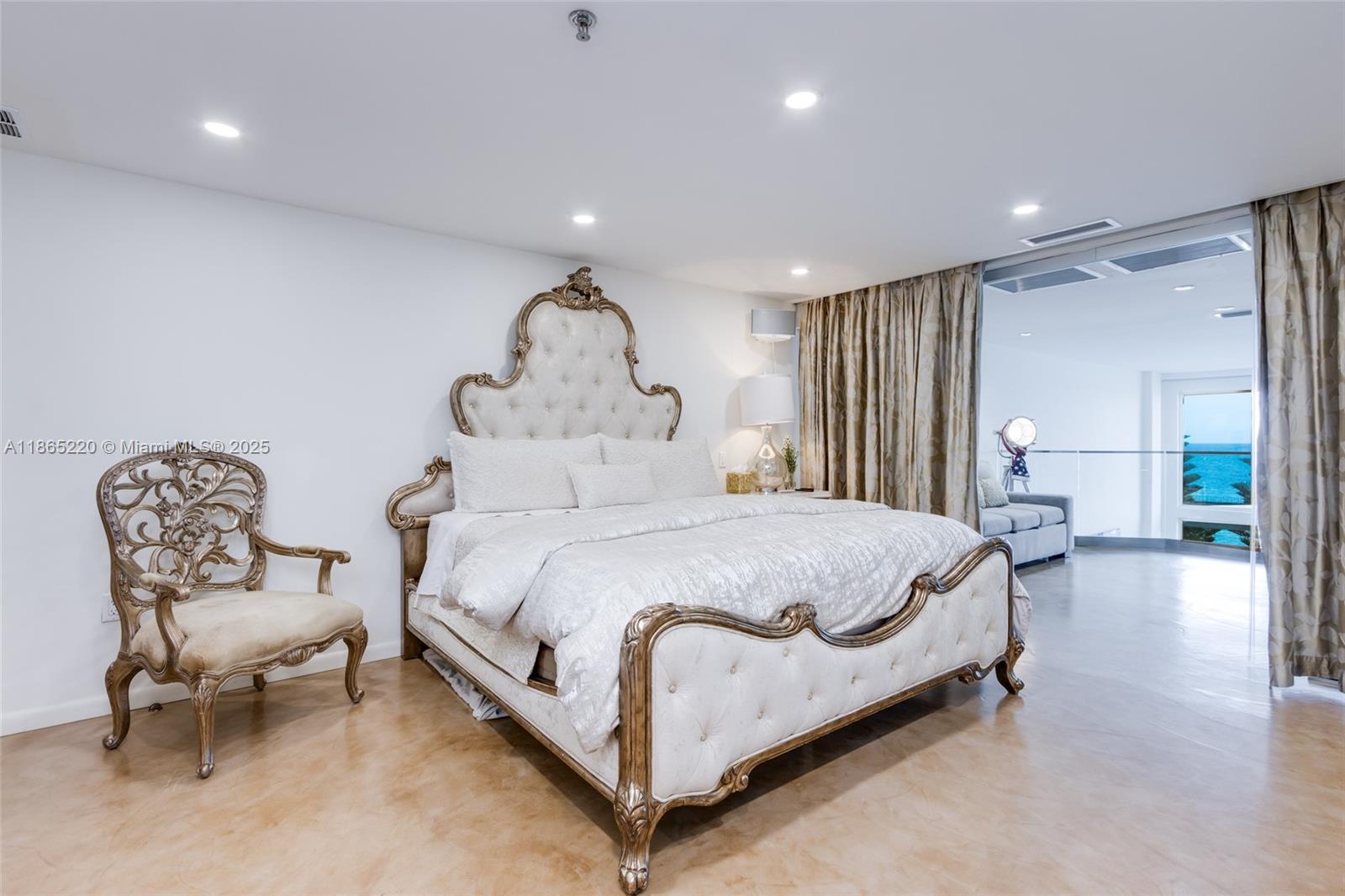5445 Collins Avenue, Unit P2 Miami Beach, FL 33140 - Photo 57 of 62 a spacious bedroom with a bed and a chandelier