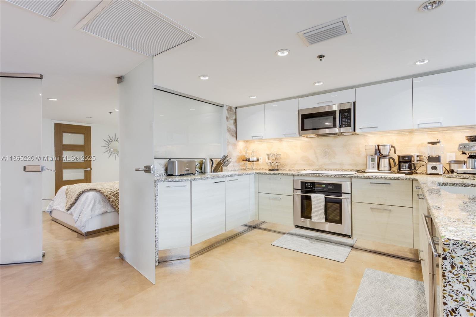 5445 Collins Avenue, Unit P2 Miami Beach, FL 33140 - Photo 7 of 62 a kitchen with granite countertop a sink stove and refrigerator