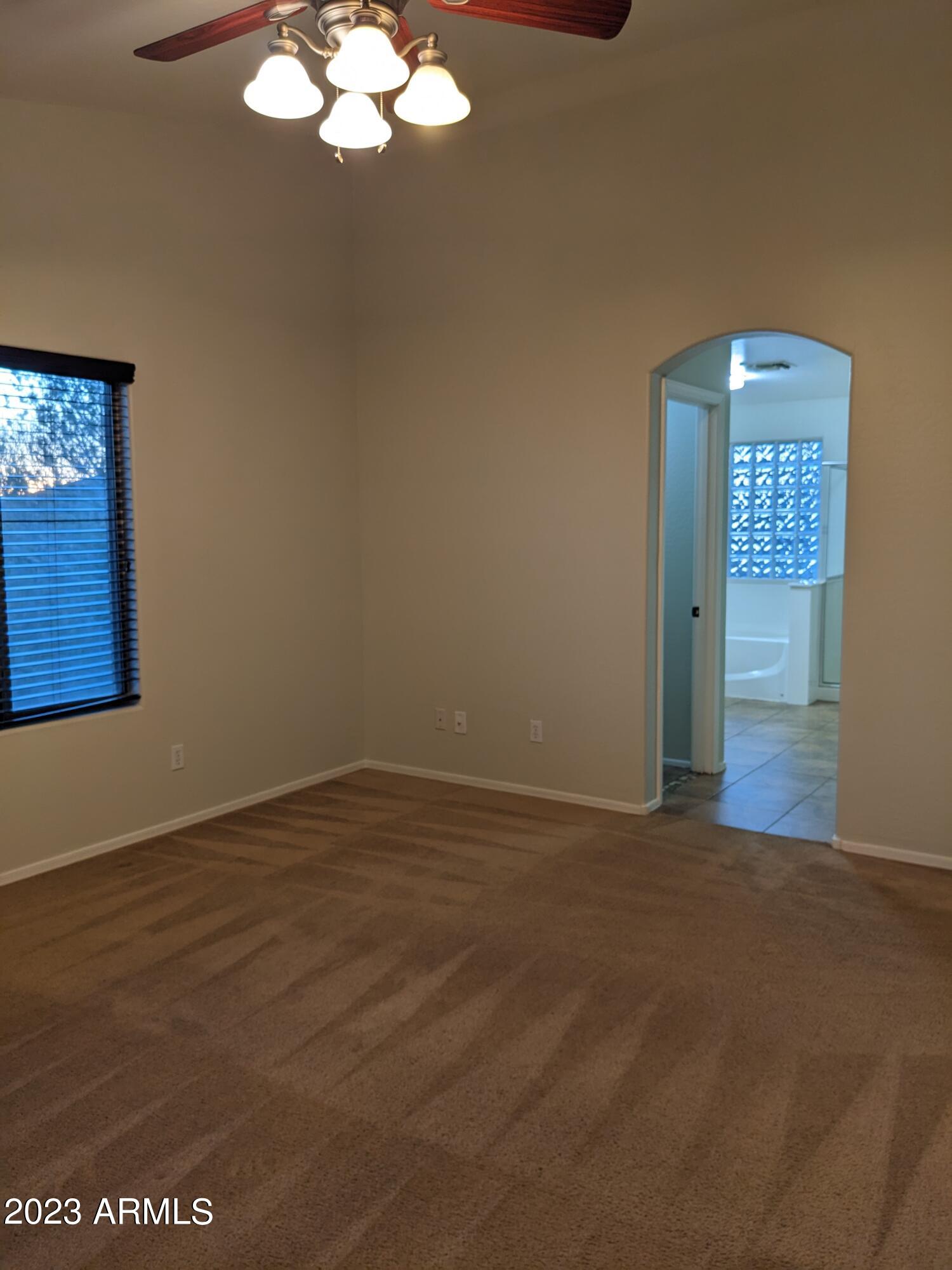 14099 West Riviera Drive Surprise, AZ 85379 - Photo 15 of 27 a view of an empty room with wooden floor and a window