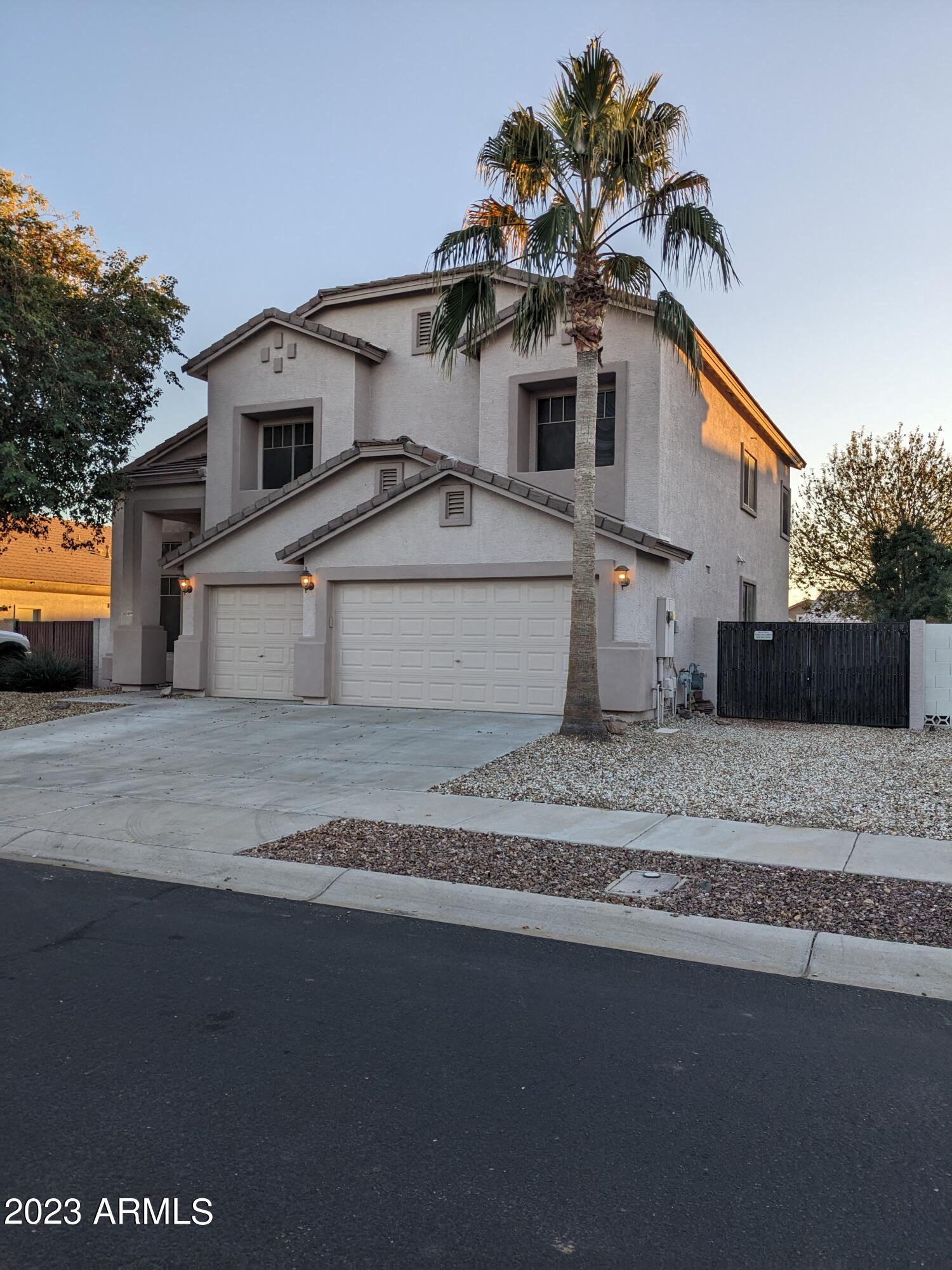 14099 West Riviera Drive Surprise, AZ 85379 - Photo 2 of 27 a front view of a house with a yard and garage