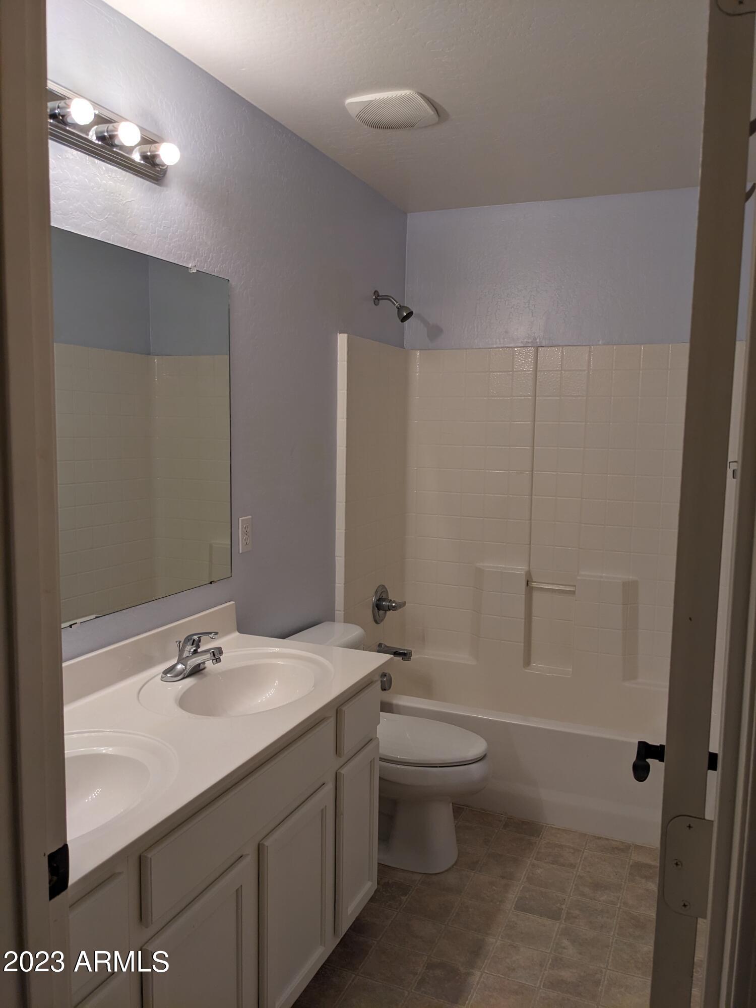 14099 West Riviera Drive Surprise, AZ 85379 - Photo 23 of 27 a bathroom with a double vanity sink toilet and shower