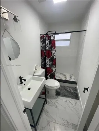a bathroom with a sink toilet and shower
