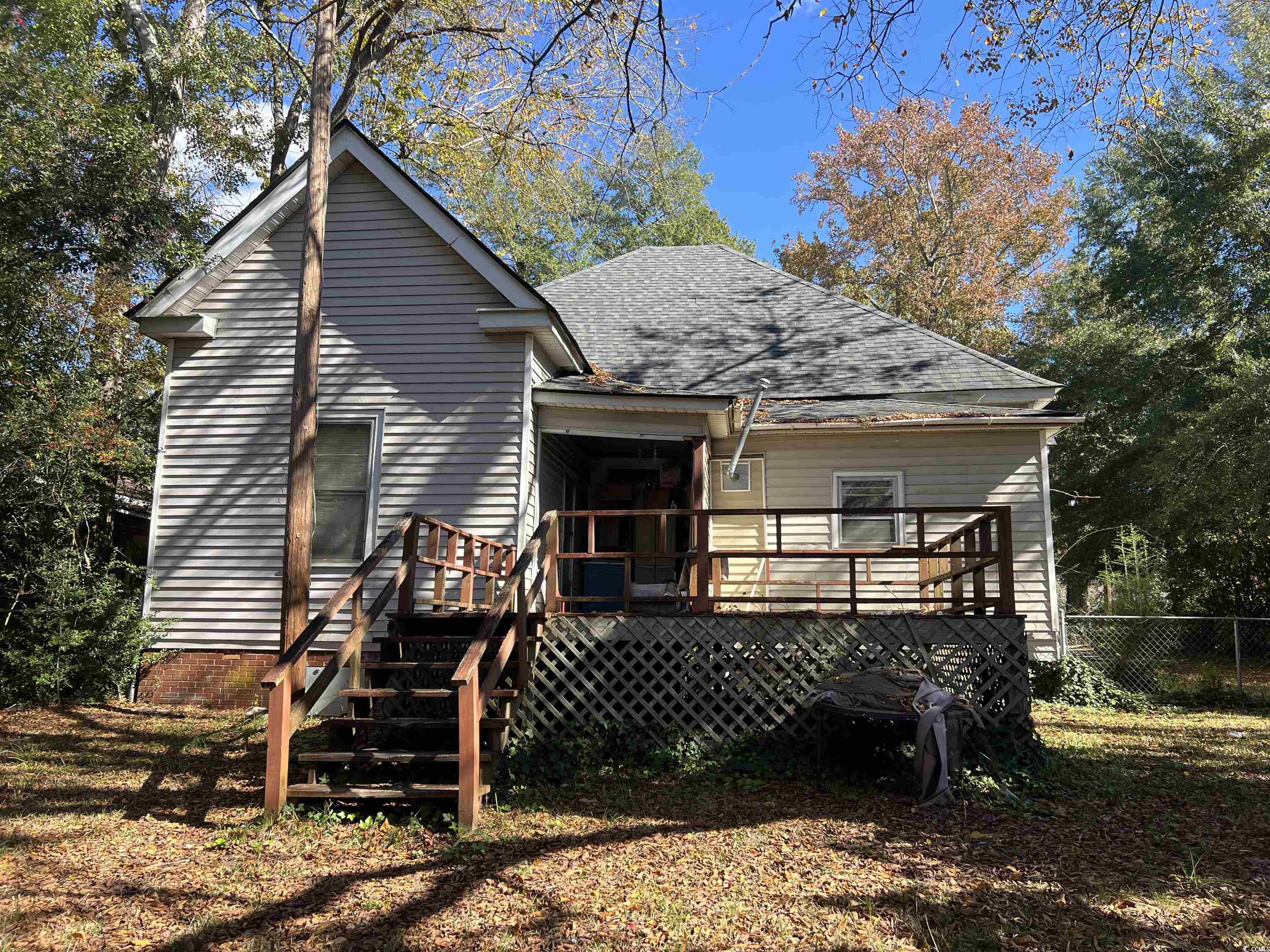 110 Gordon Street Kingstree, SC 29556 - Photo 4 of 8 Rear view of property featuring a wooden deck, roof with shingles, stairway, and a sunroom