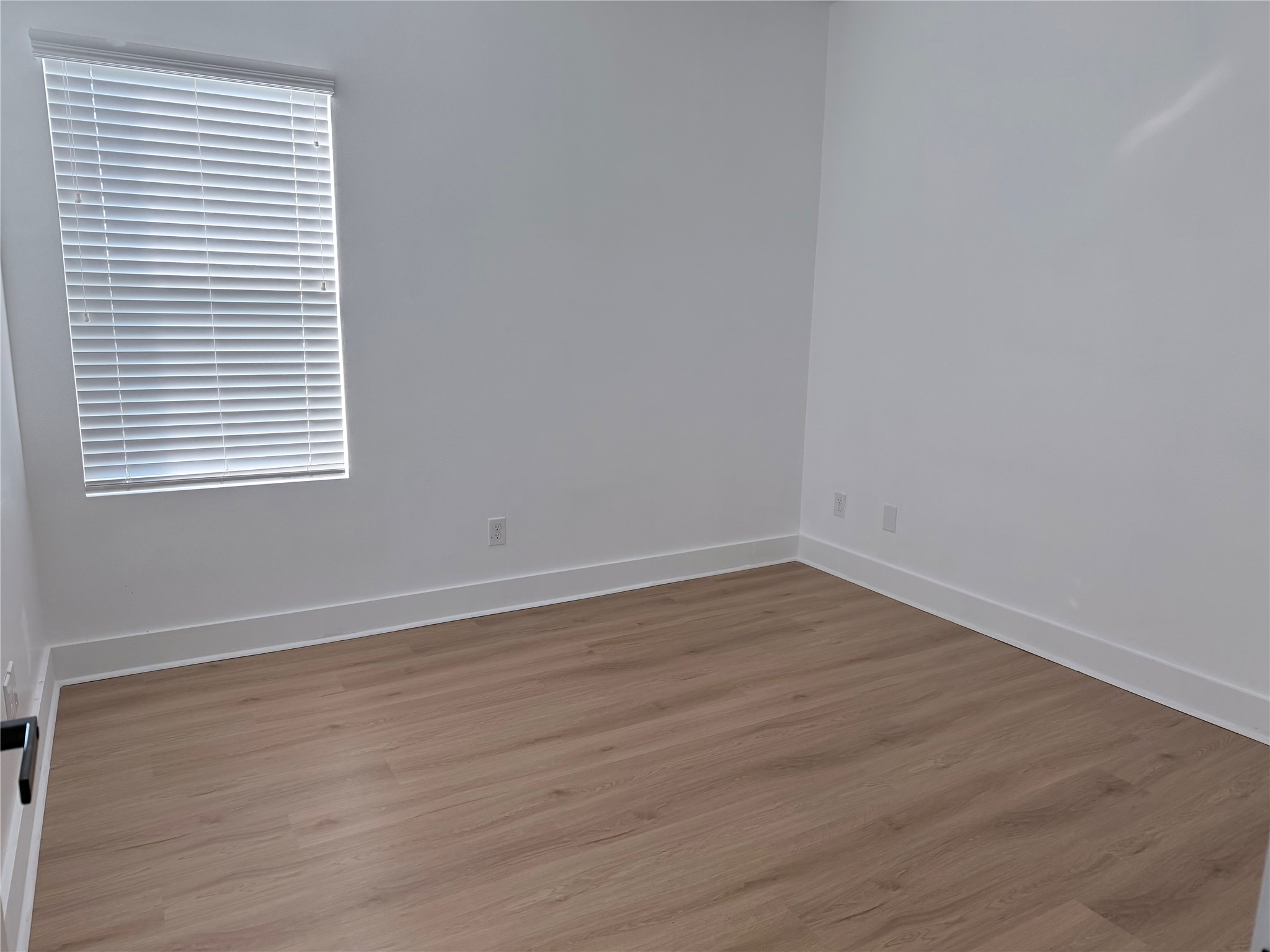 5928 Conley Street Houston, TX 77021 - Photo 11 of 12 a view of an empty room with wooden floor and a window
