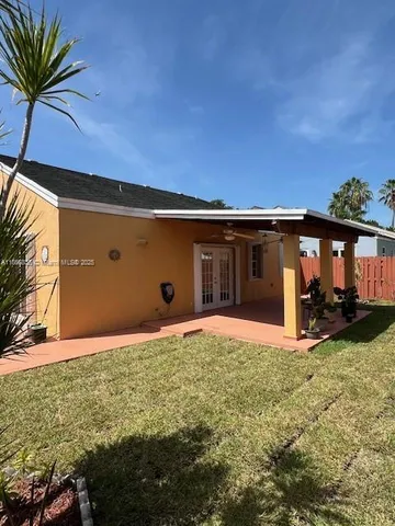 a backyard of a house with table and chairs