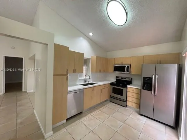 a kitchen with stainless steel appliances granite countertop a refrigerator and a stove top oven