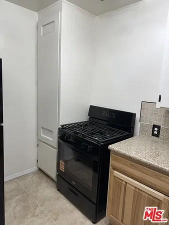 a stove top oven sitting inside of a kitchen