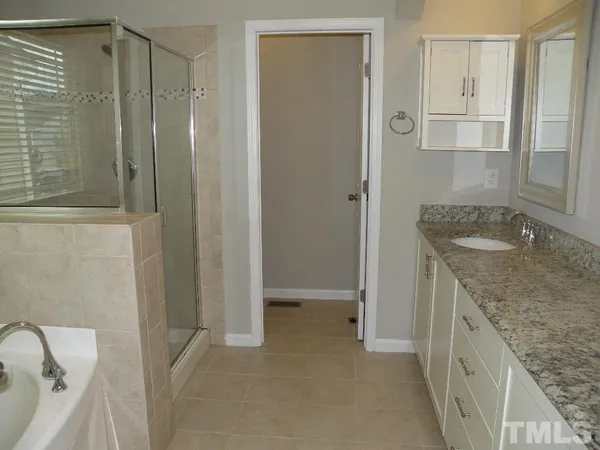 a bathroom with a granite countertop sink a toilet and shower