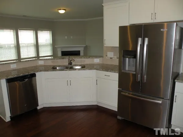 a kitchen with a refrigerator sink and cabinets