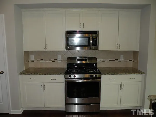 a stove top oven sitting inside of a kitchen