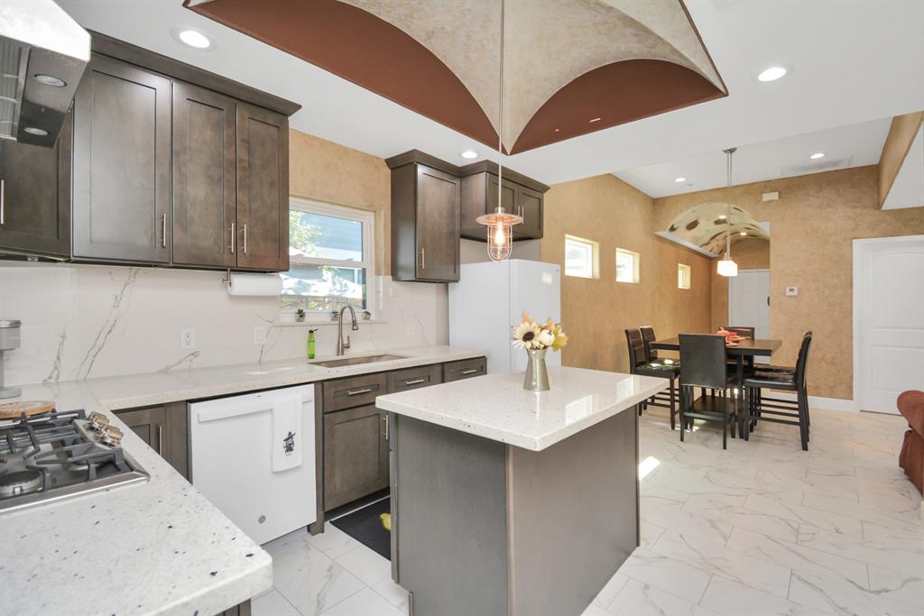 2705 Fox Street Houston, TX 77003 - Photo 12 of 20 a kitchen with a sink a stove and chairs