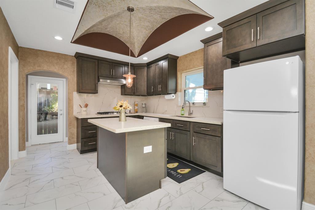 2705 Fox Street Houston, TX 77003 - Photo 10 of 20 a kitchen with a sink a refrigerator and cabinets