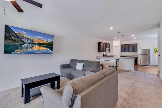 a living room with furniture and kitchen view
