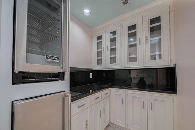 a kitchen with stainless steel appliances granite countertop white cabinets and black granite counter tops