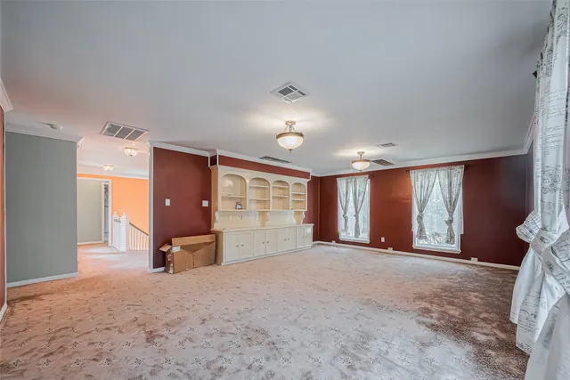 en empty room with windows and cabinet