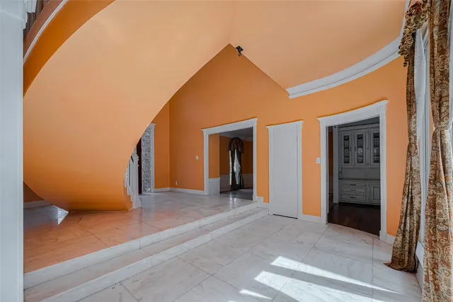 a view of a big room with wooden floor and entryway