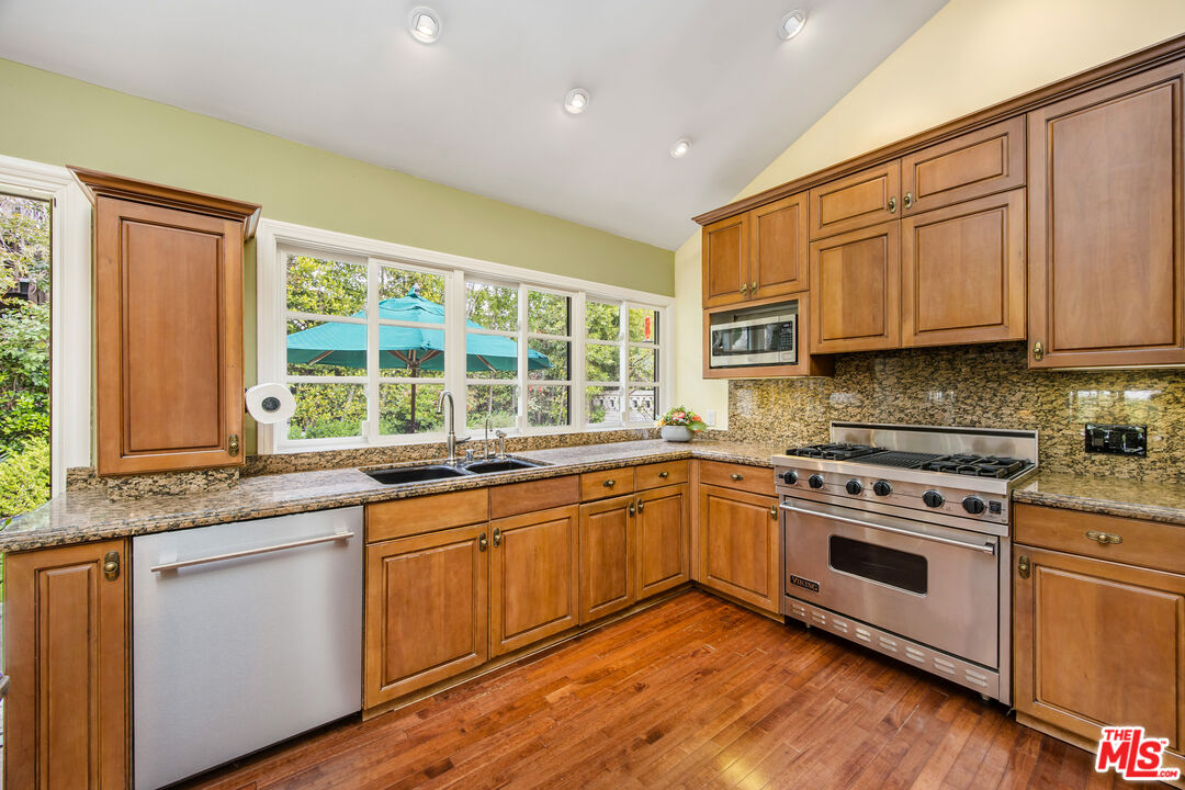 2124 Eric Drive Los Angeles, CA 90049 - Photo 12 of 30 a kitchen with stainless steel appliances granite countertop wooden cabinets and a stove top oven