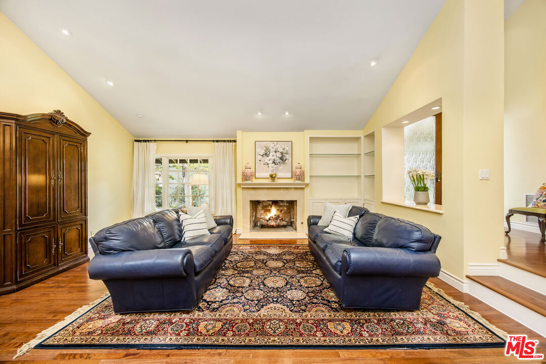 2124 Eric Drive Los Angeles, CA 90049 - Photo 6 of 30 a living room with furniture a rug and a fireplace
