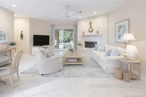 a kitchen with stainless steel appliances granite countertop a sink a stove a refrigerator cabinets a dining table and chairs