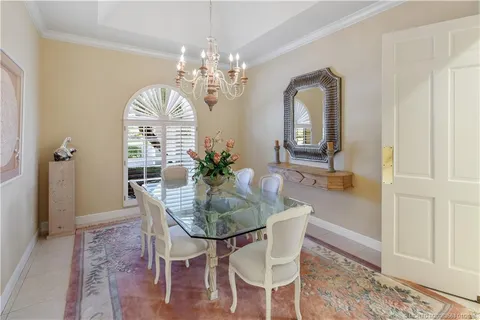 a view of a dining room with furniture a chandelier and wooden floor