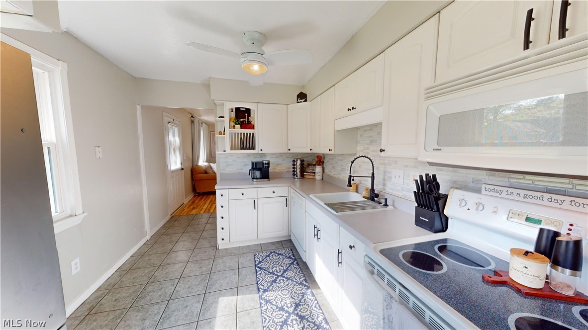 4796 Forest Road Mentor, OH 44060 - Photo 4 of 34 Kitchen featuring ceiling fan, light tile flooring, range, white cabinets, and sink