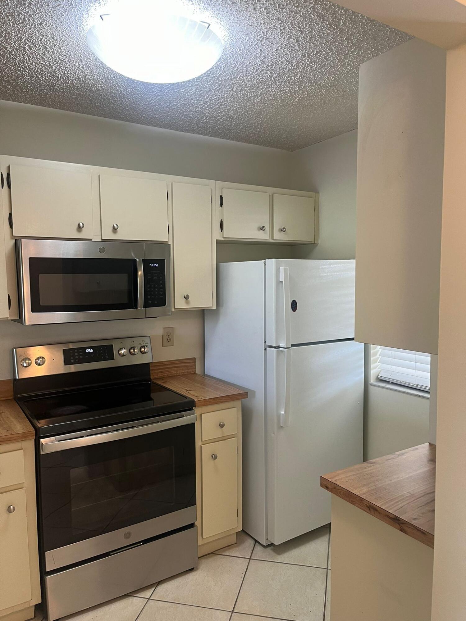 9993 Three Lakes Circle Boca Raton, FL 33428 - Photo 5 of 22 a kitchen with a refrigerator stove and microwave