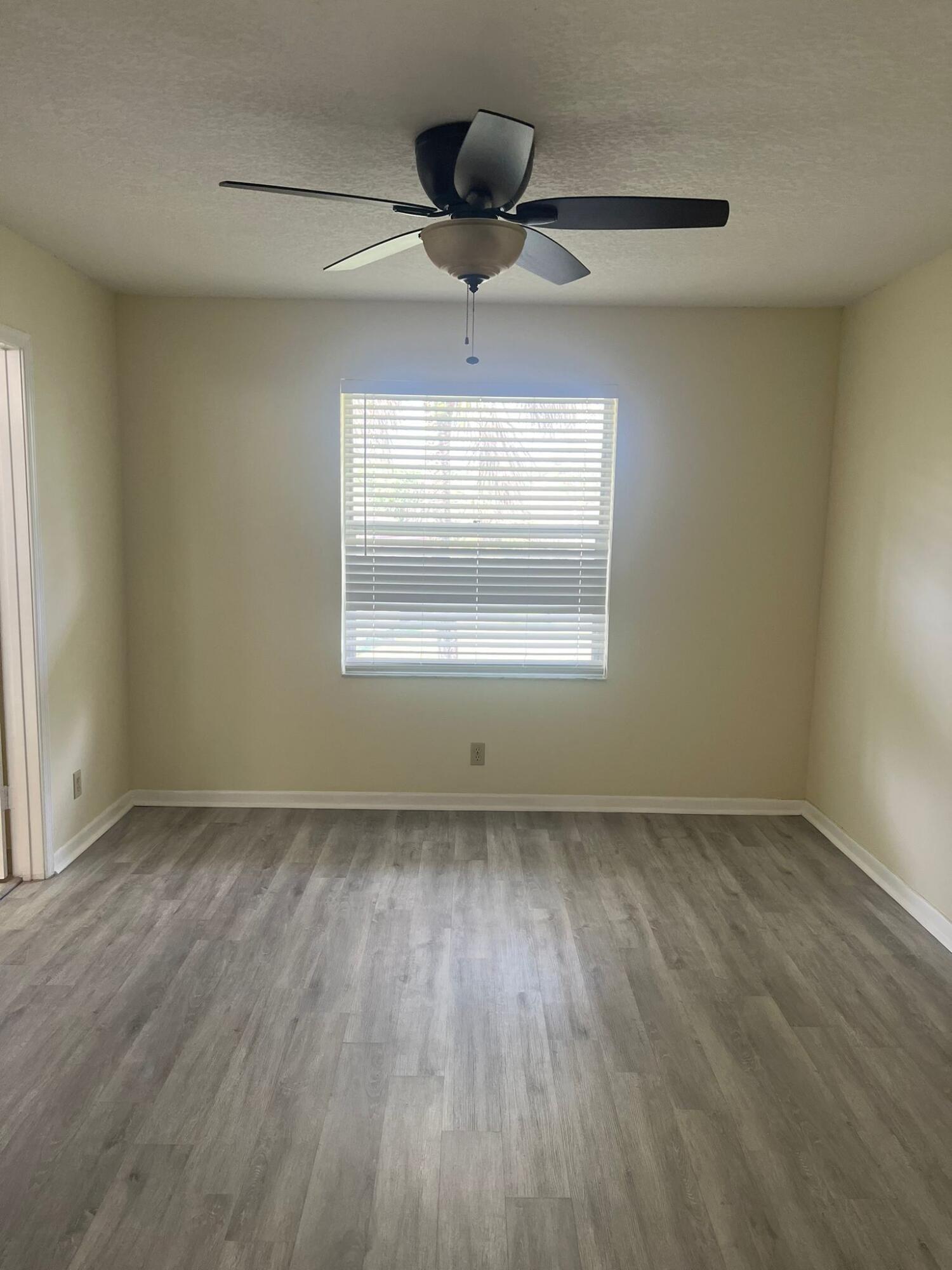 9993 Three Lakes Circle Boca Raton, FL 33428 - Photo 7 of 22 a view of an empty room with wooden floor and a window