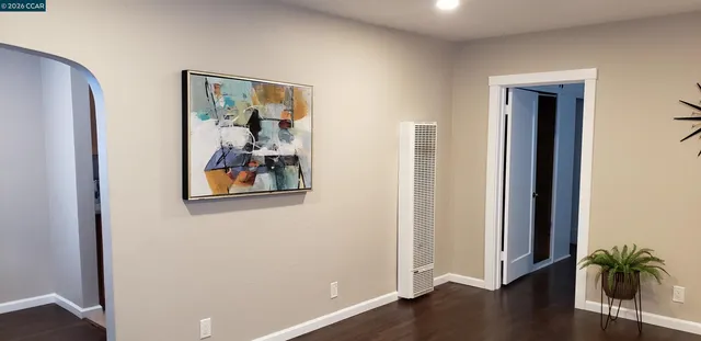 an empty room with wooden floor and a window
