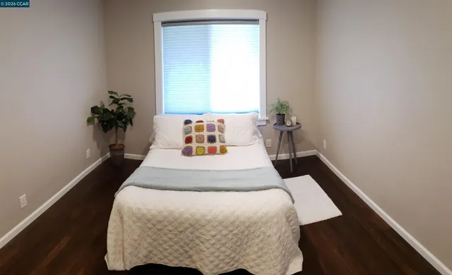 a bedroom with a bed and a potted plant