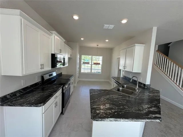 a view of a hallway to an empty room with a window