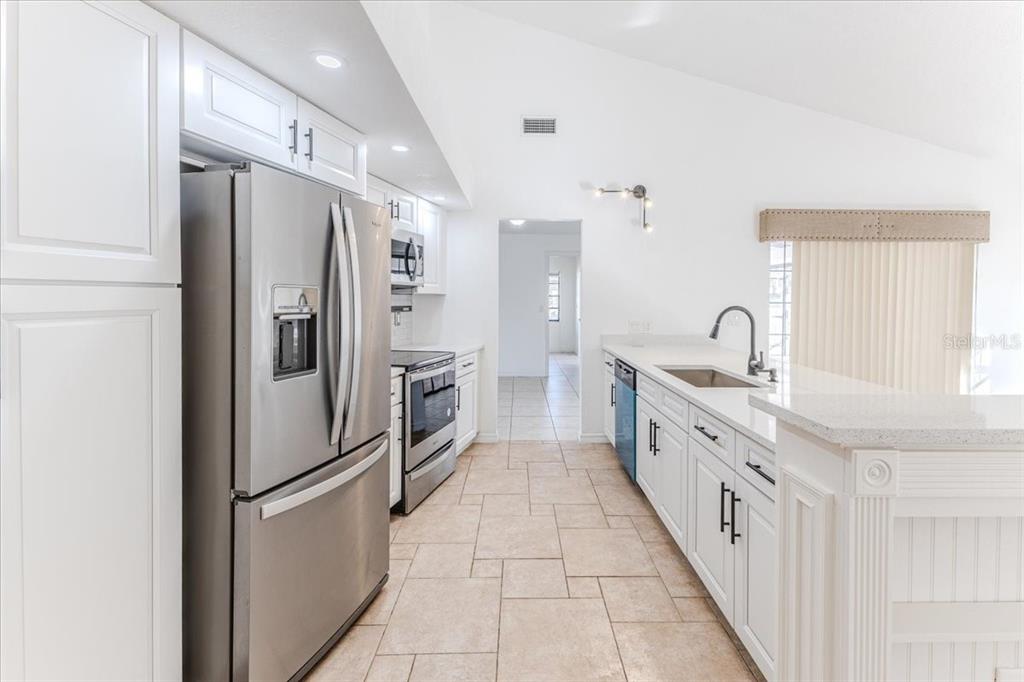 1382 Aladdin Road Spring Hill, FL 34609 - Photo 12 of 45 a kitchen with stainless steel appliances a refrigerator sink and cabinets
