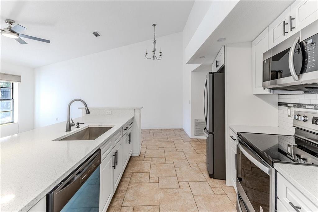1382 Aladdin Road Spring Hill, FL 34609 - Photo 14 of 45 a kitchen with stainless steel appliances granite countertop a sink and a stove