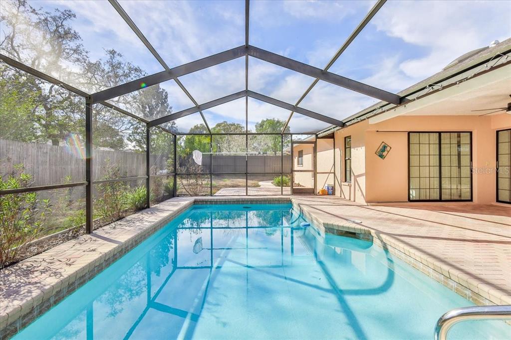 1382 Aladdin Road Spring Hill, FL 34609 - Photo 4 of 45 a swimming pool with large glass windows and painted walls